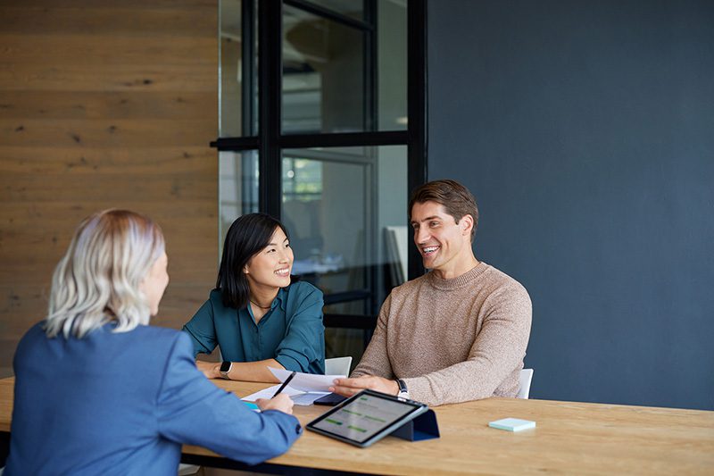 Woman meeting with a couple to discuss property management services